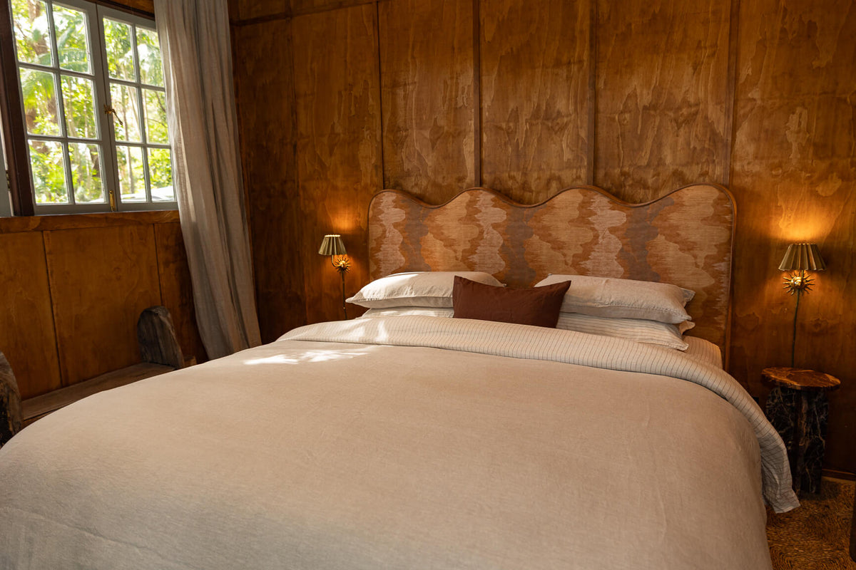 Neatly made bed with canyon sheet set in a warm-toned room.