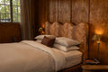 NESTD luxury flax linen bedding featuring Canyon and Dune white layers, styled with matching pillows and a draped duvet against a warm textured headboard.