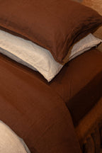 Sable bedding set with a Dune and Sable pillow on a bed.