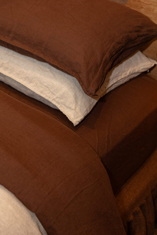 Sable bedding set with a Dune and Sable pillow on a bed.